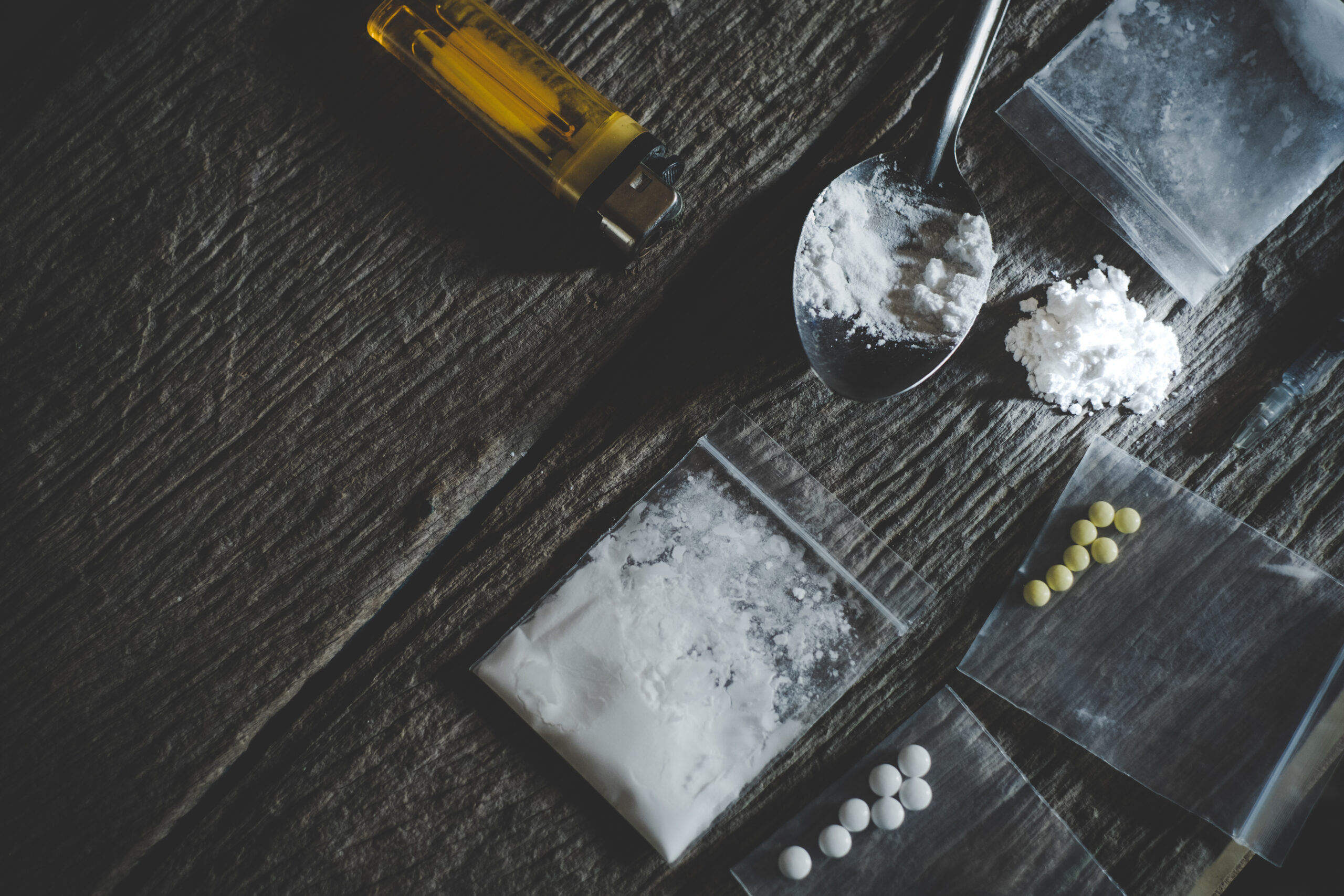 the drug crank on a wooden table with paraphernalia, showing what symptoms of a crank addiction can look like