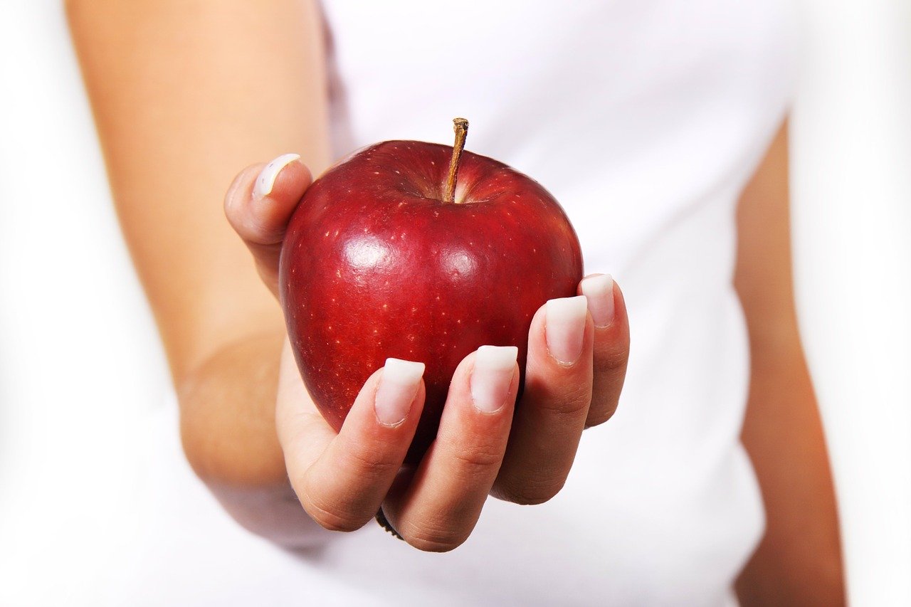 an image of a woman holding an apple, healthy foods to eat, healthy eating, healthy places to eat near me, healthy eating near me, healthy eating plan