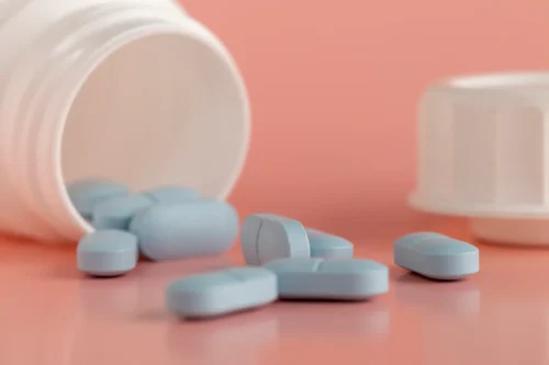 Zoloft withdrawal symptoms. Spilled blue pills on table.